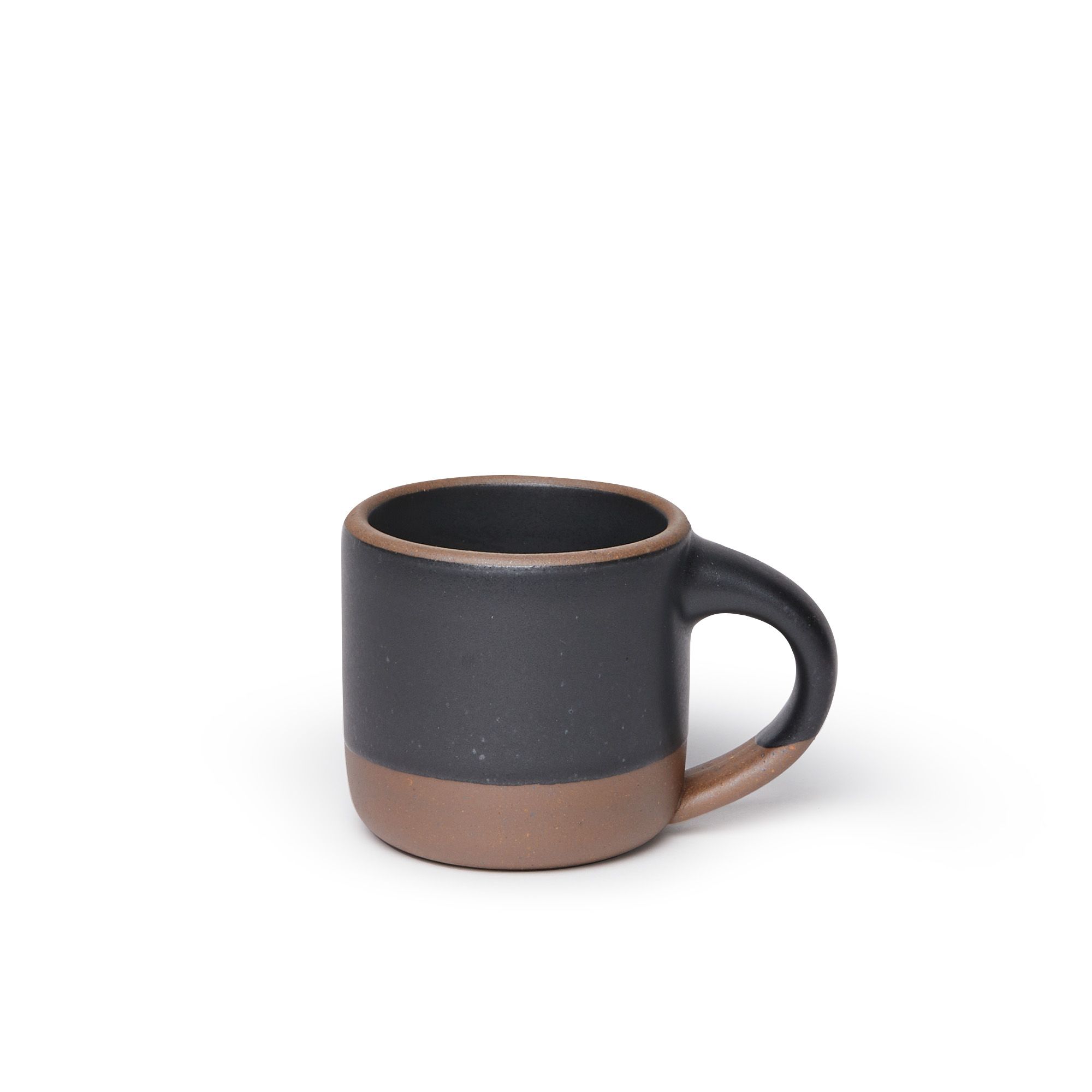 A small sized ceramic mug with handle in a graphite black glaze featuring iron speckles and unglazed rim and bottom base.