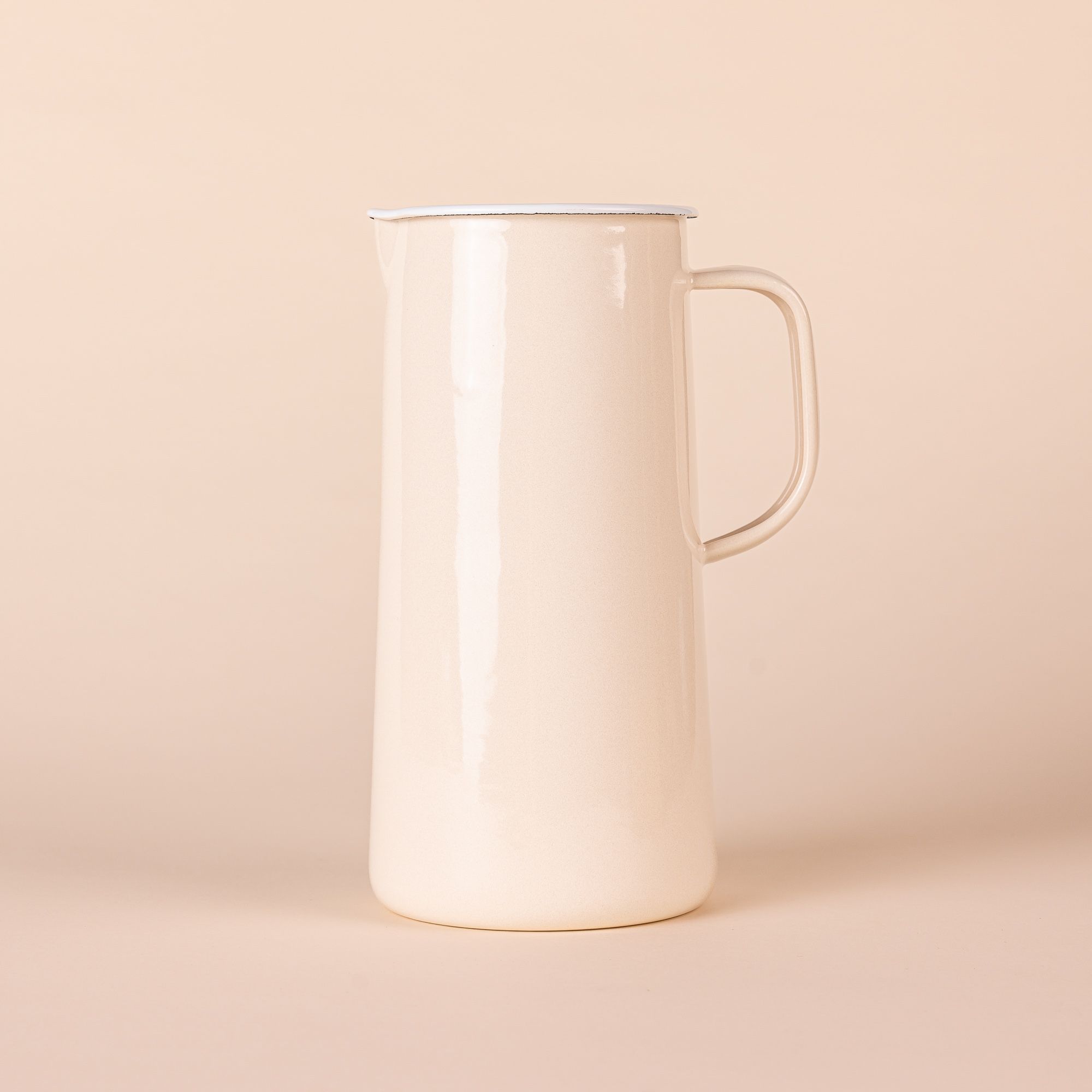 Shiny cream cylindrical jug, with white interior, a spout on the left, and a handle on the right