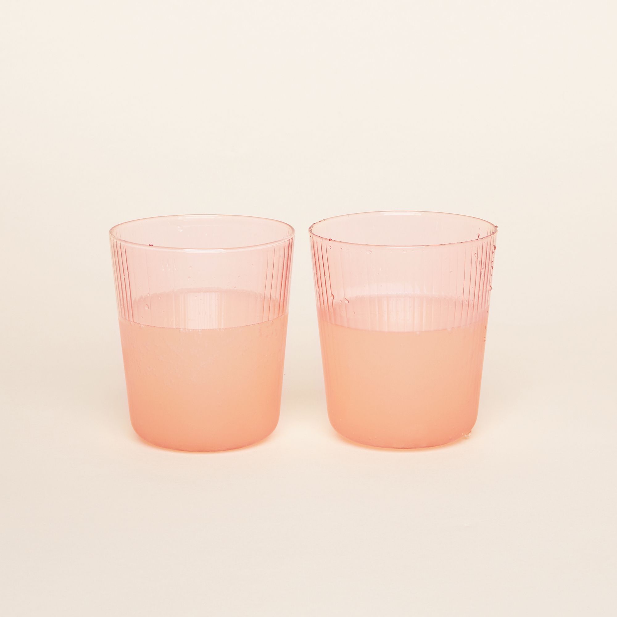 Water glasses that come in three pale, translucent color glasses: yellow, green, pink. The cups have vertical grooves.