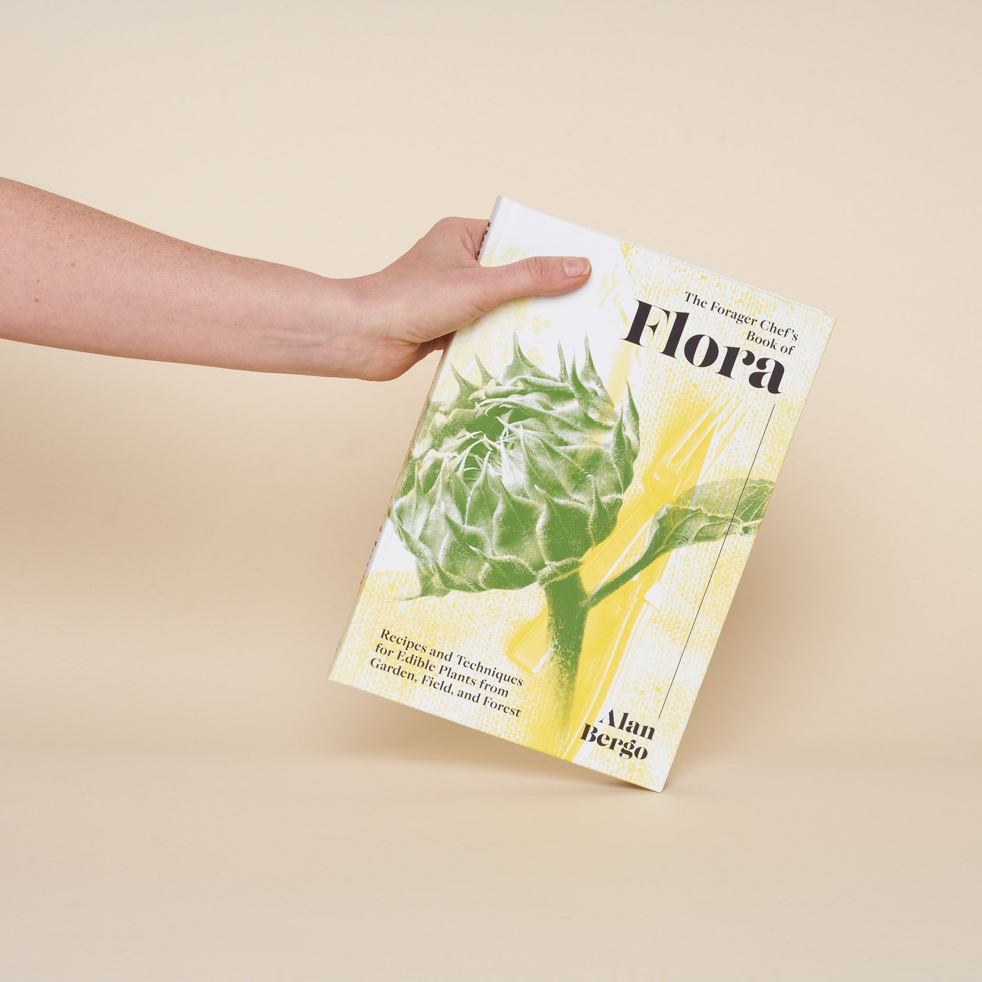 A white book with a green and yellow illustration of a soon-to-bloom sunflower head