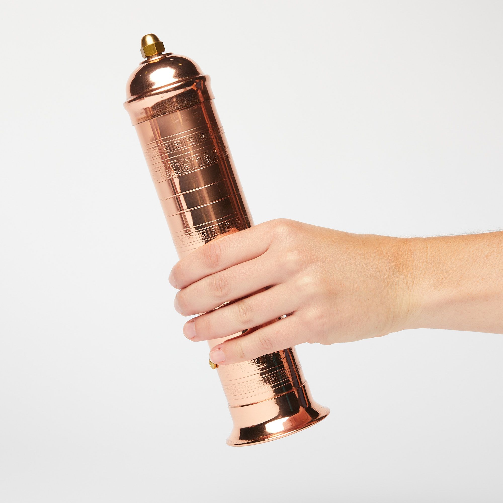Hand holding copper pepper mill out