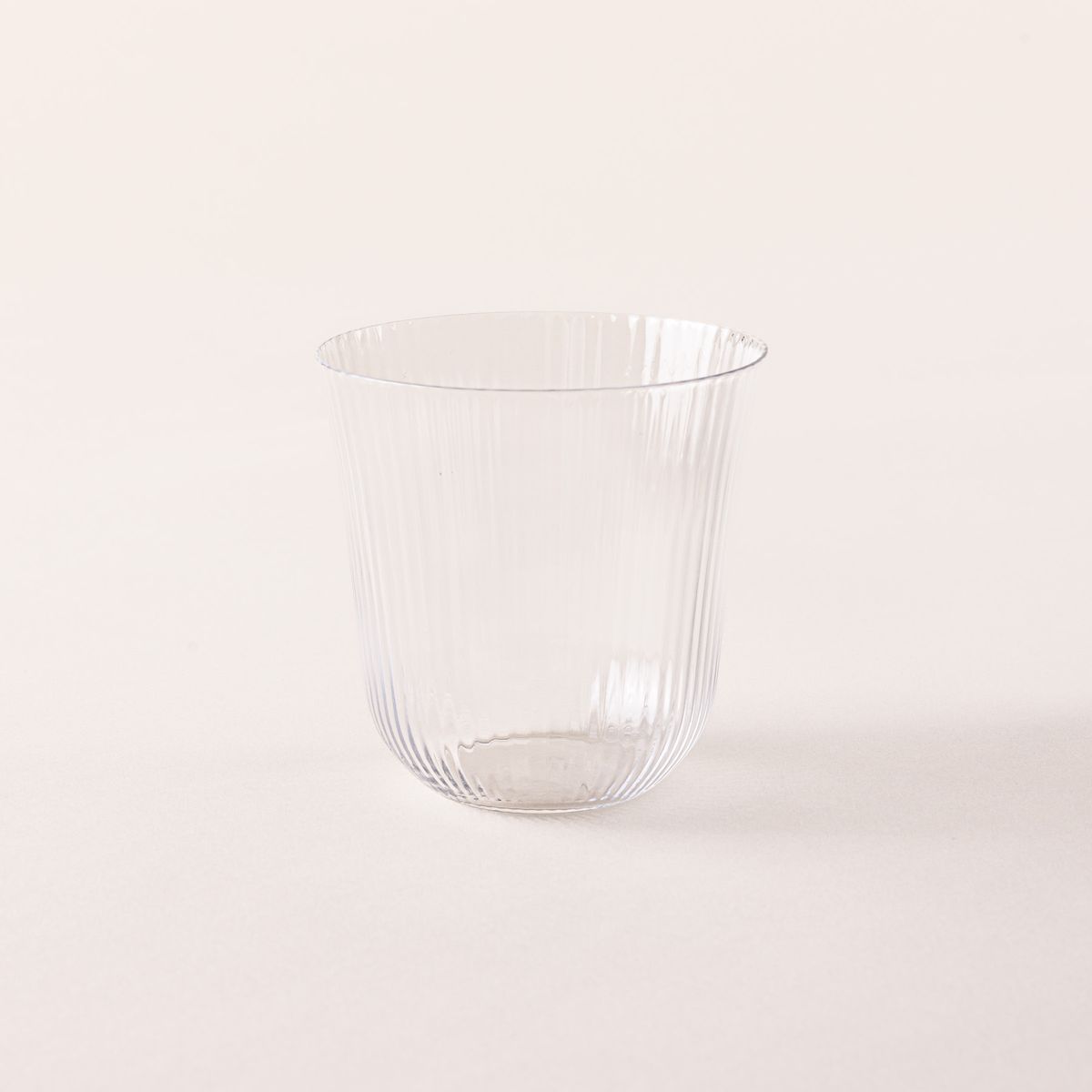 A delicate ribbed glass that has a rounded curve on the bottom and curves out on the top.