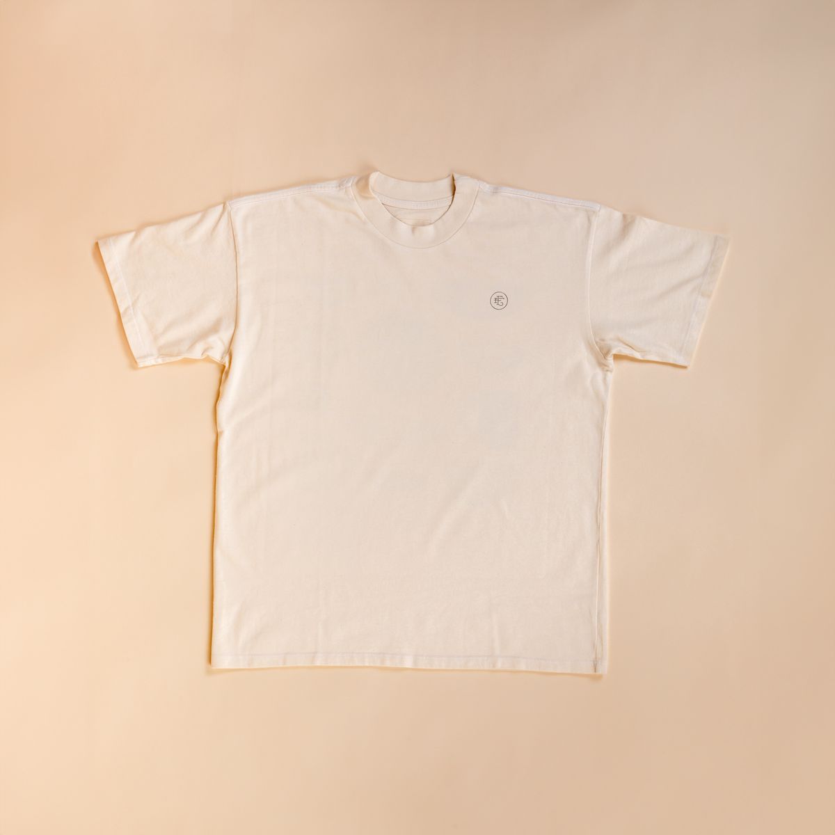 Flat lay t-shirt in cream against a cream background.  On the top right corner of the tee is a little 'East Fork' EF Logo.