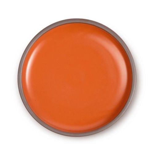 A dinner plate with a raw clay rim and bright orange interior