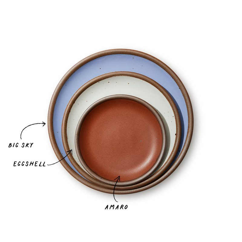 A stack of 3 plates in Dinner, Side, and Cake sizes in a periwinkle, white, and terracotta colors.