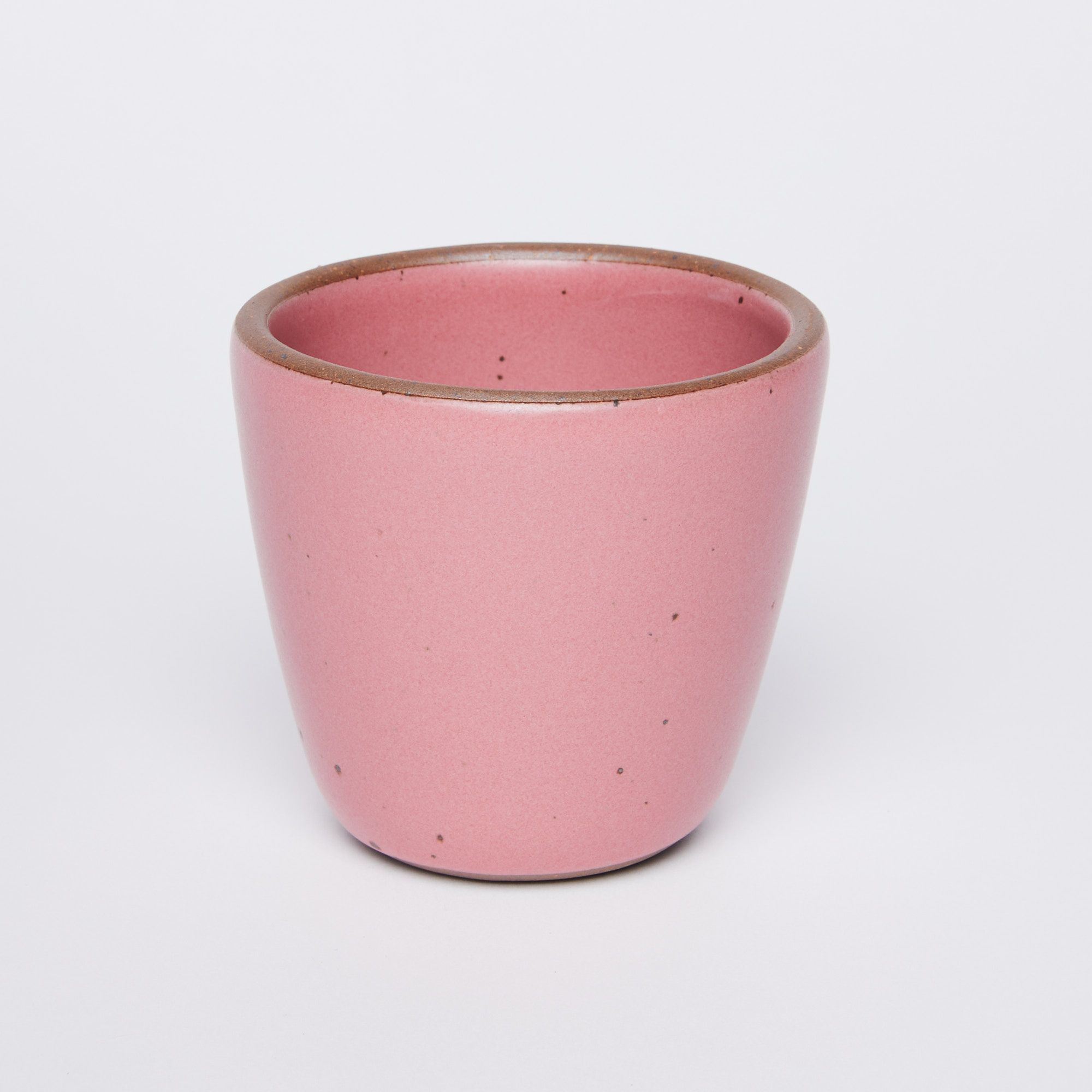 short cup that tapers out to get wider at the top in Rococo (pink) glaze