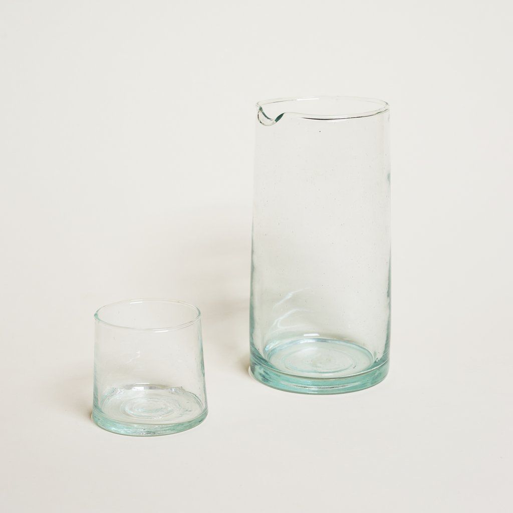 A short, clear glass cylinder drinking glass and a matching pitcher