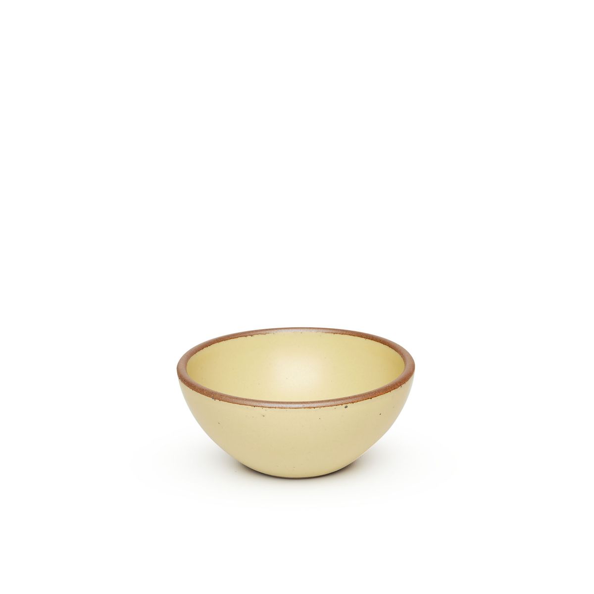 A small dessert sized rounded ceramic bowl in a light butter yellow color featuring iron speckles and an unglazed rim