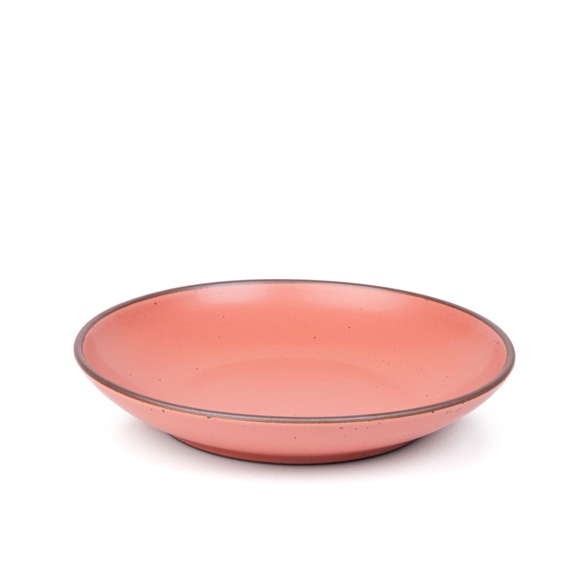 A large ceramic plate with a curved bowl edge in a watermelon pink color featuring iron speckles and an unglazed rim.