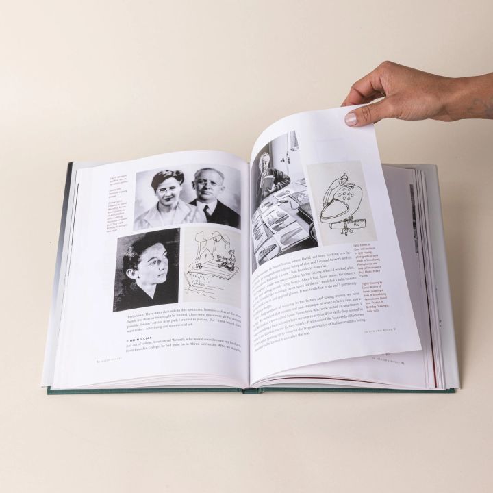 An open hardcover book called "A Chosen Path" flipped to a page featuring old black and white photos of people, as well as drawings and text.