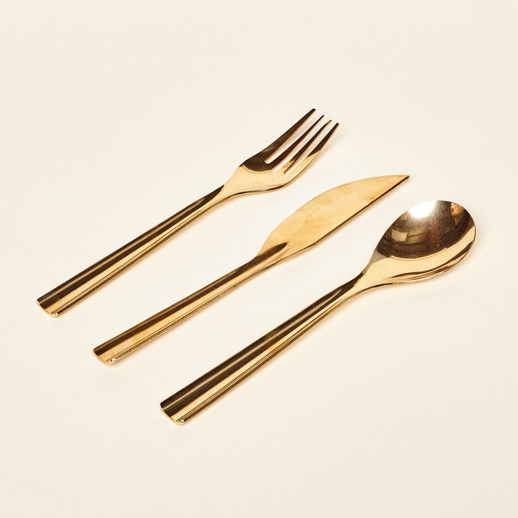 A shiny brass fork, knife and spoon