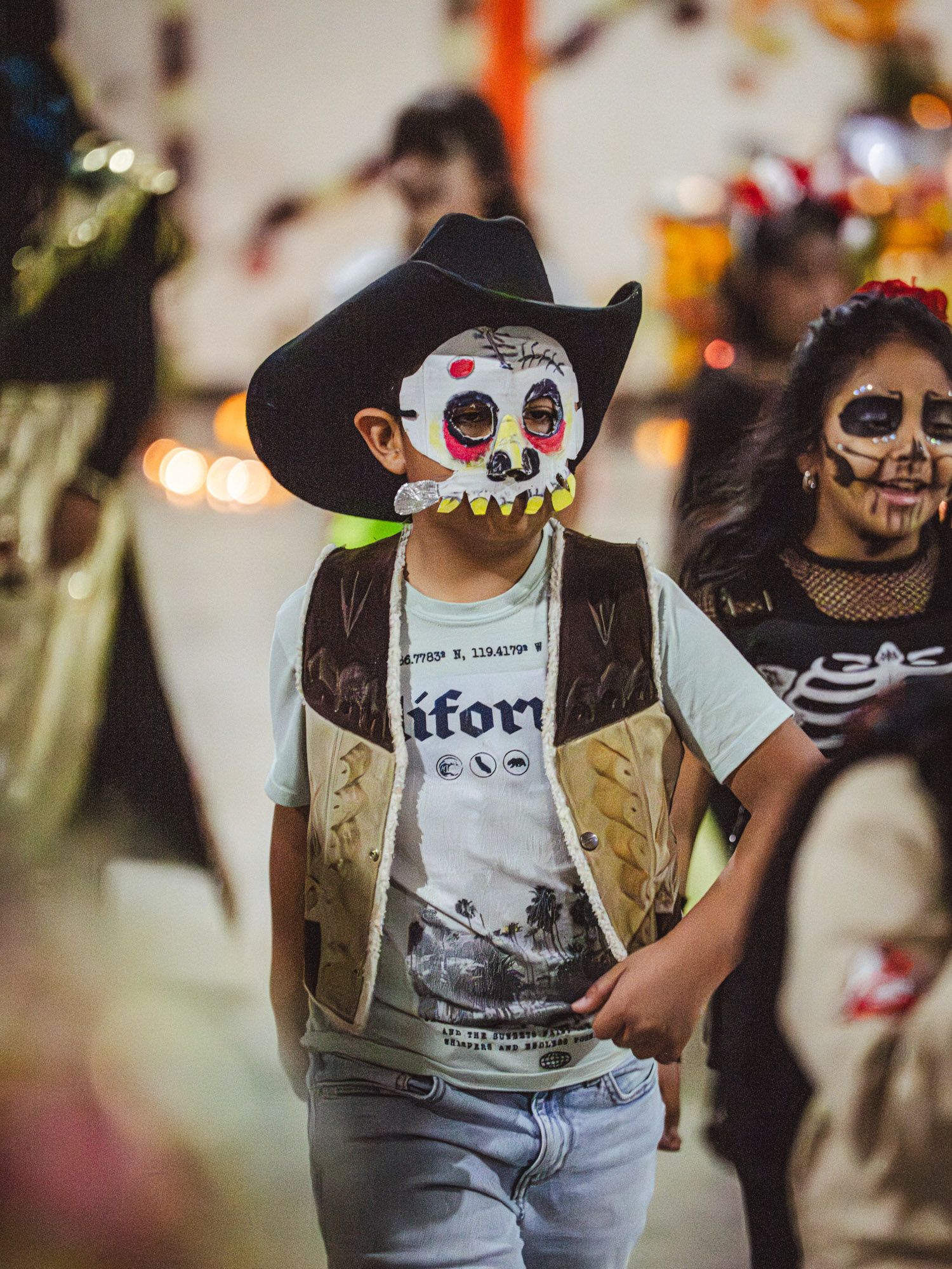 Two children dancing in face paint and face masks at a festival