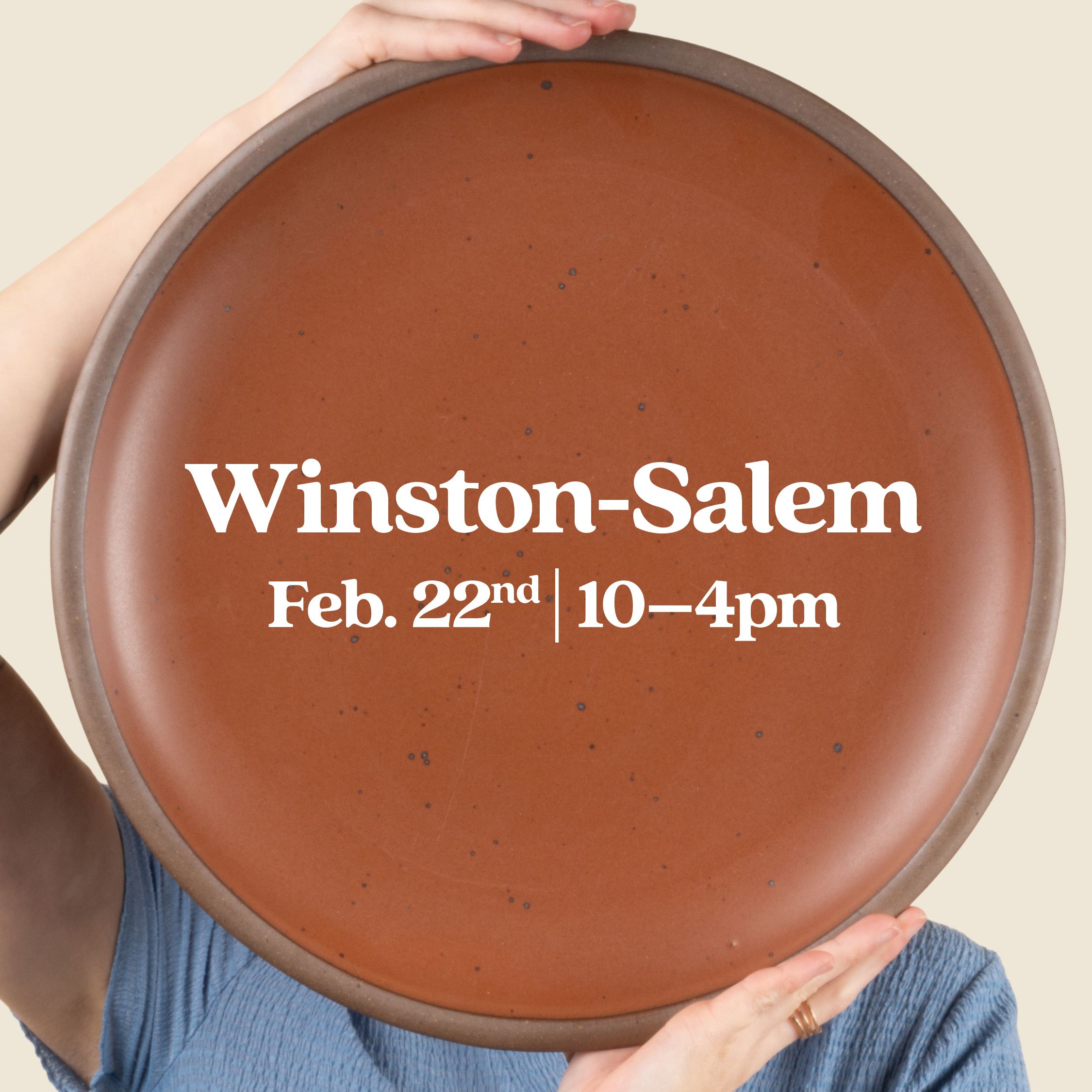 Hands hold up a large platter in a cool terracotta color with text overlay that reads 'Winston-Salem Feb. 22 10-4pm'