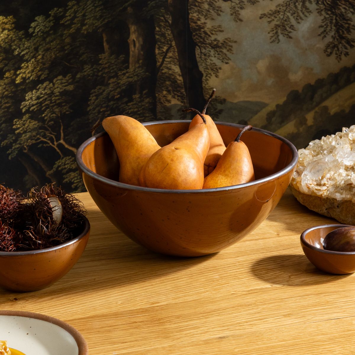 Glossy caramel brown ceramic serving bowl with pears, paired with a small matching bowls on a wooden table.