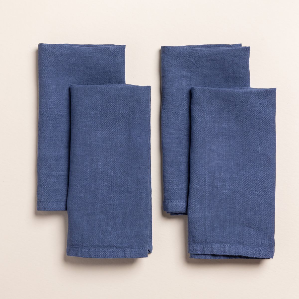 4 folded linen napkins in a blue color