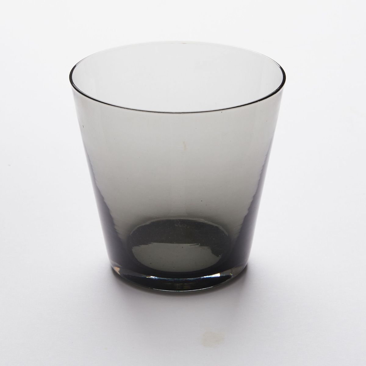 A short drinking glass made of black colored glass