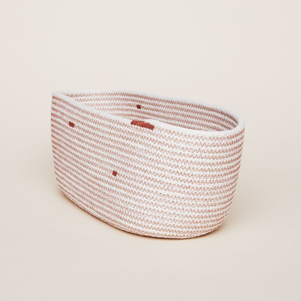 Side view of The Northern Market Bread Basket with beige woven body and dark red thread