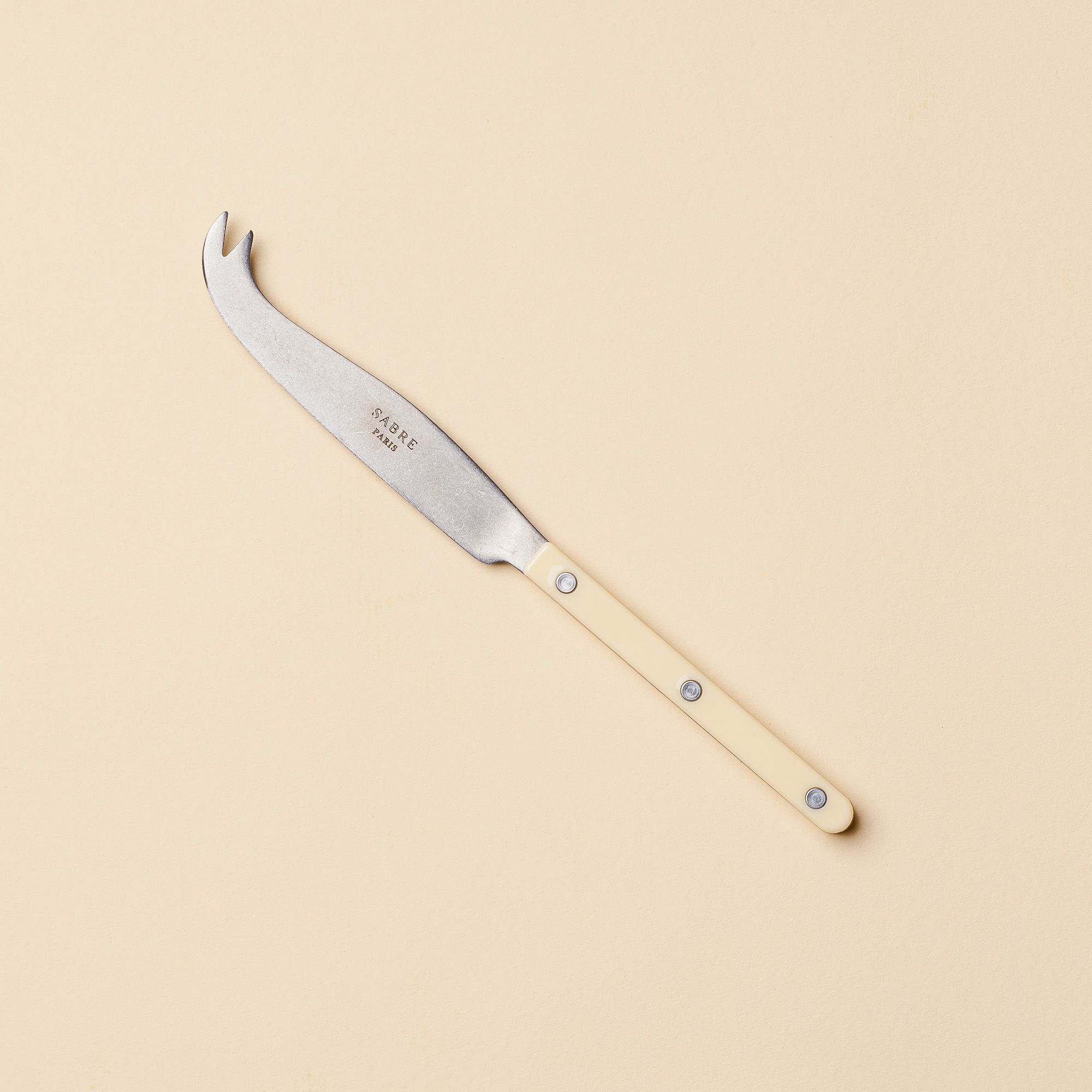 A stylish long and thin cheese knife with a matte acrylic handle and a scooped tip