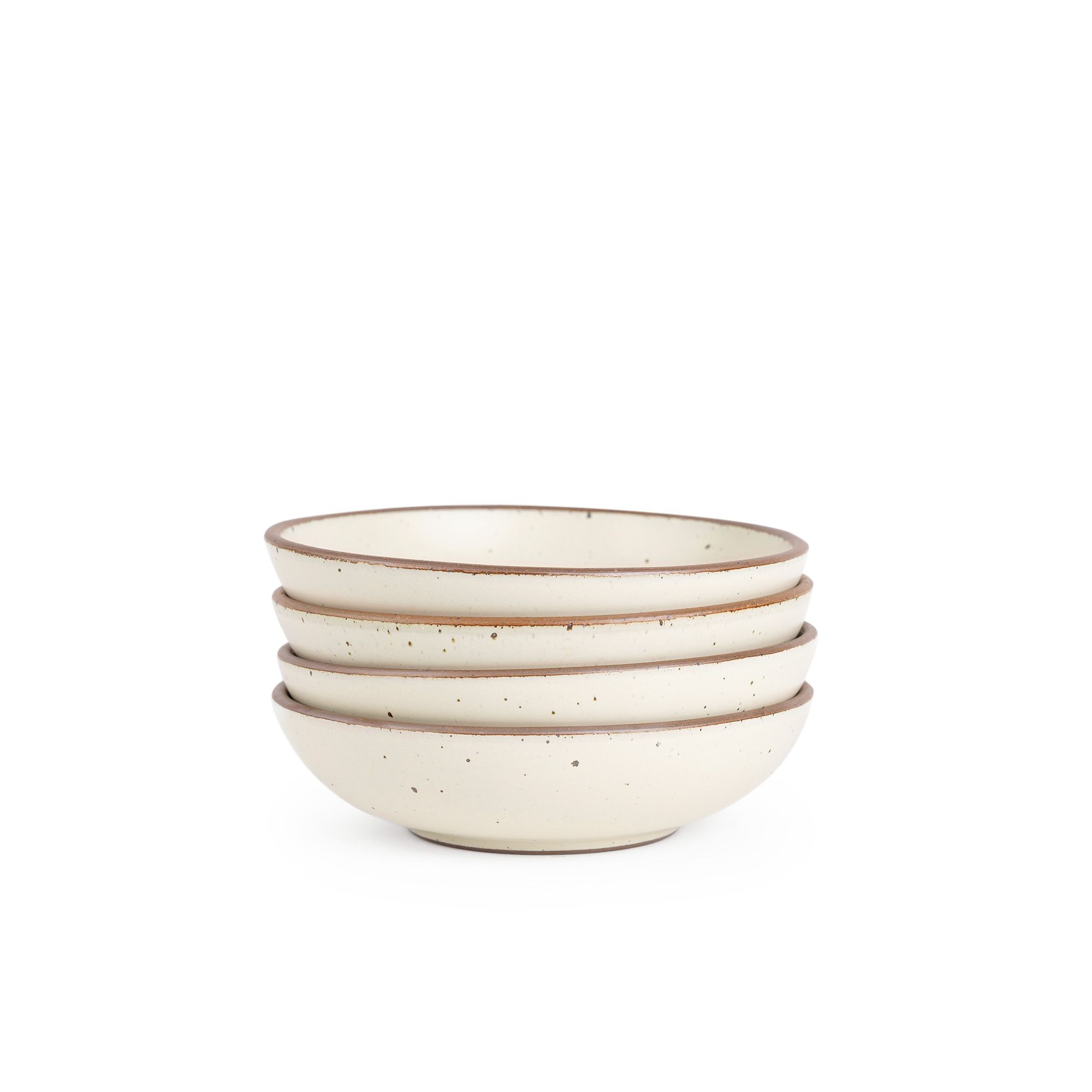 A stack of 4 dinner-sized shallow ceramic bowls in a warm, tan-toned, off-white color featuring iron speckles and an unglazed rim