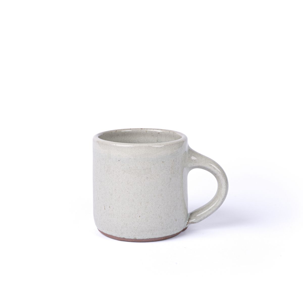 A medium sized ceramic mug with handle in a reactive icy white color featuring iron speckles