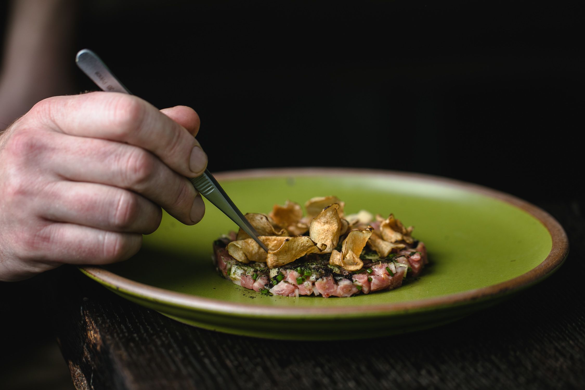 James, Bacchanalia's sous chef, puts the finishing touches on beef tartare.
