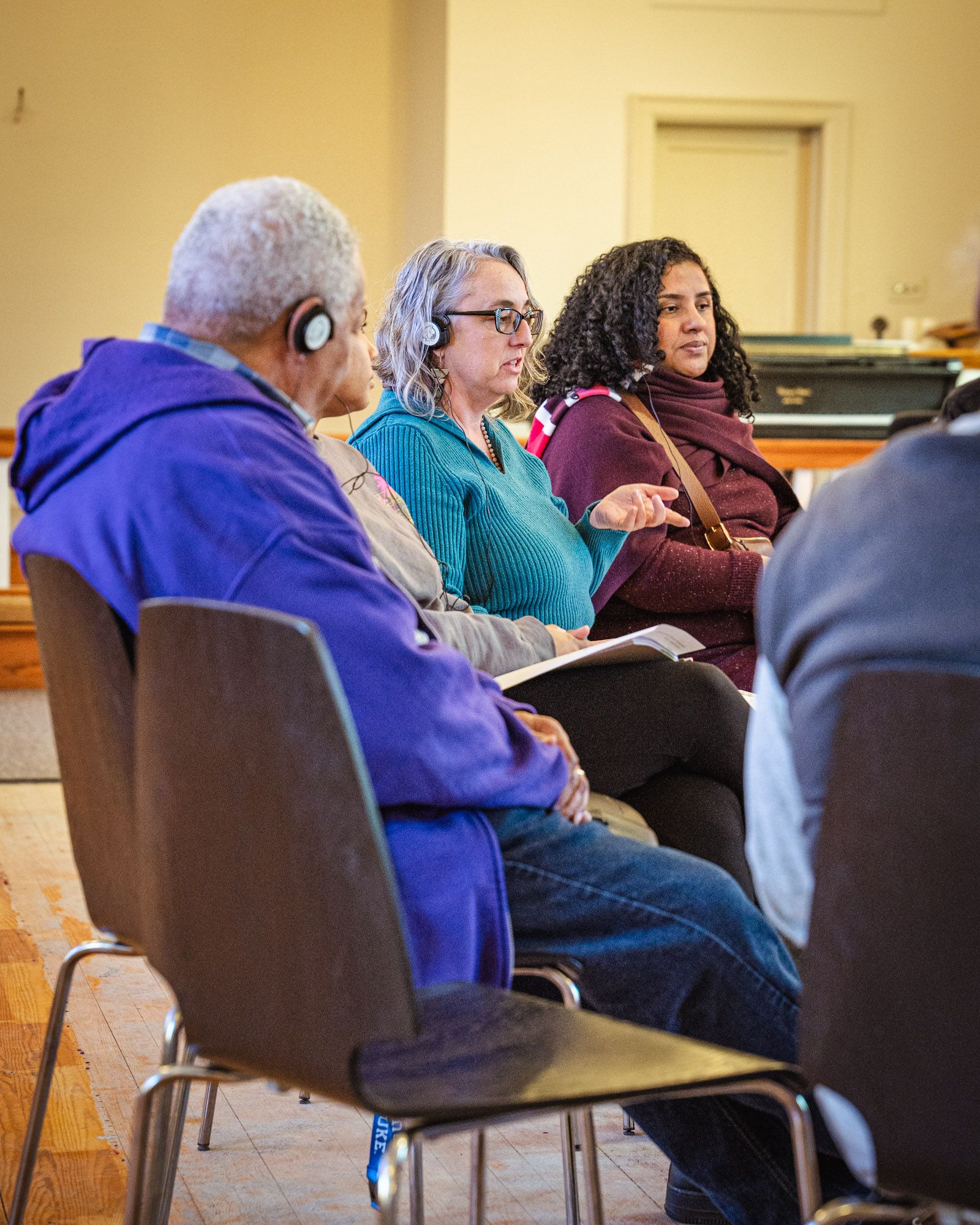 A diverse group of people gathered in a circle in the middle of conversation.