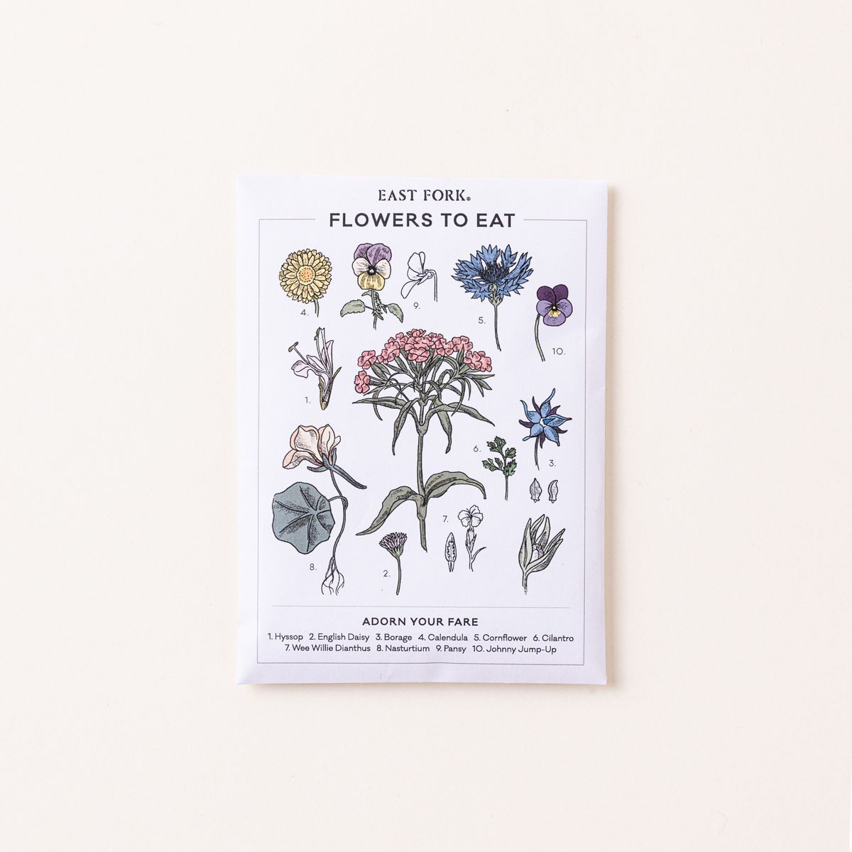 A white seed pack that reads "Flowers To Eat" with colorful floral stem illustrations