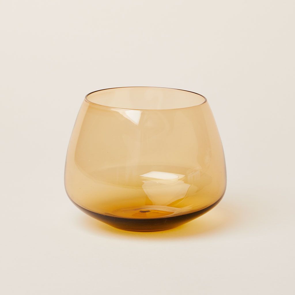 A short drinking glass in amber glass