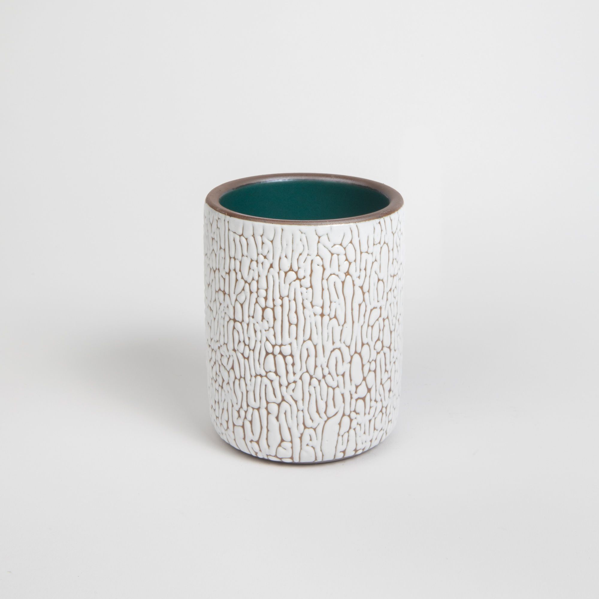 A medium white ceramic vessel with cracked texture and the interior being dark teal