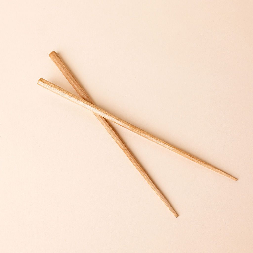 Simple pair of light wood chopsticks stacked over each other