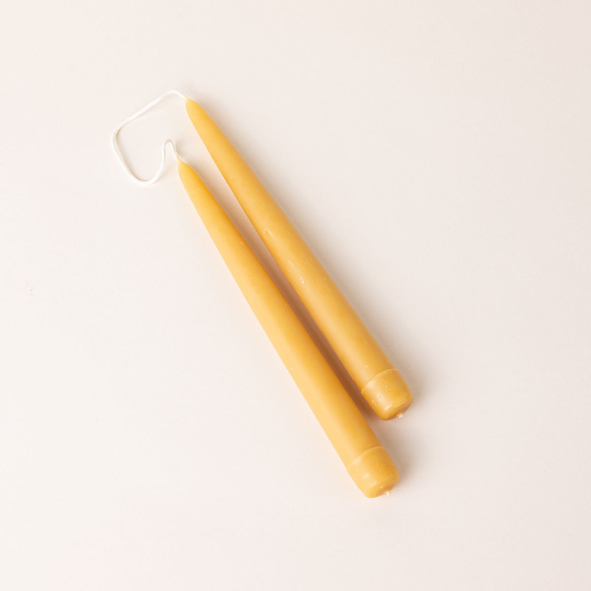 A pair of yellow beeswax taper candles