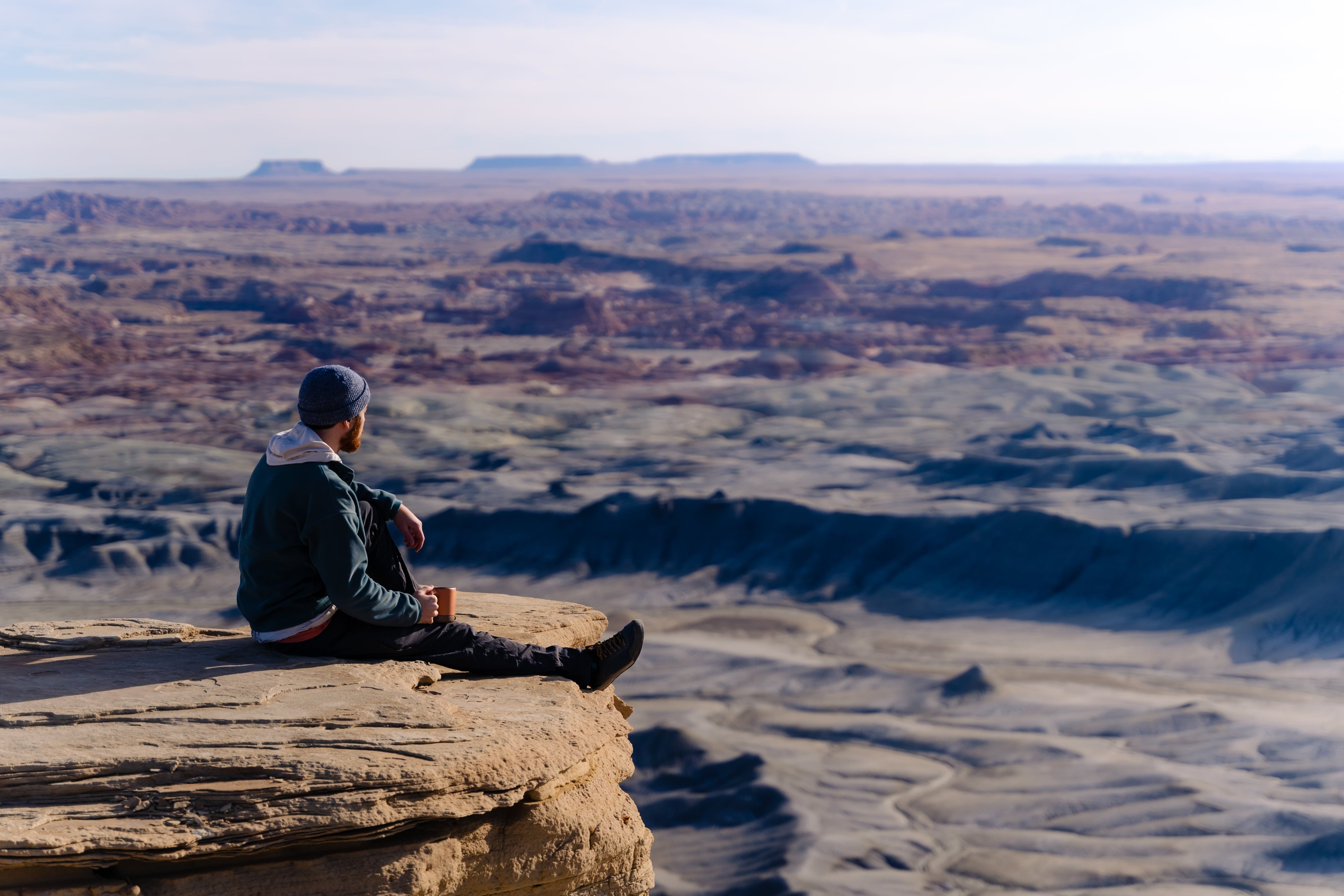 Marcus Catlett photo of man hanging out on cliff edge with Mug in Utah
