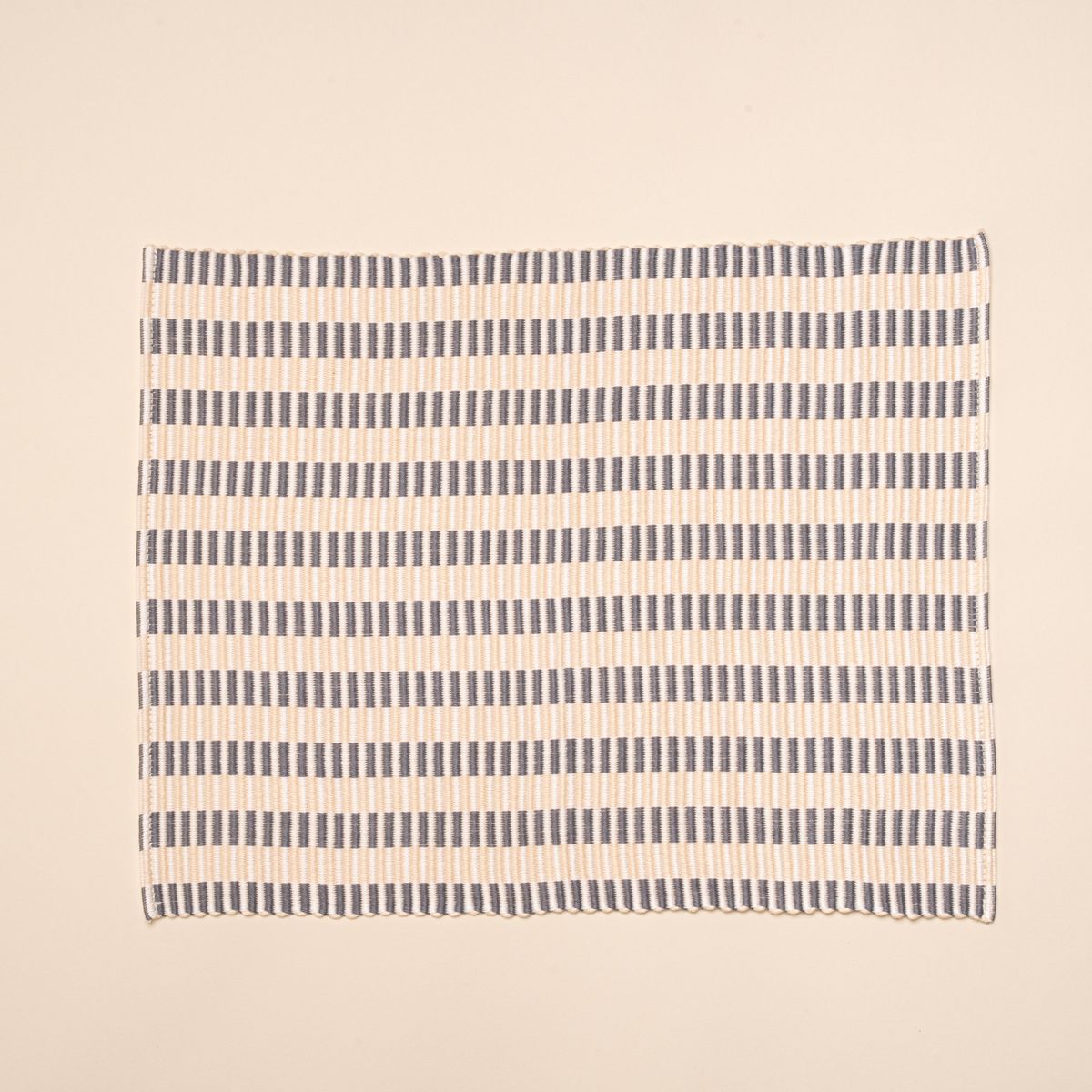 A woven placemat with thin horizontal striped grey and natural colors