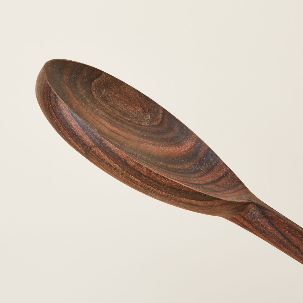 Close-up of the bowl of a walnut serving spoon, showing wood grain