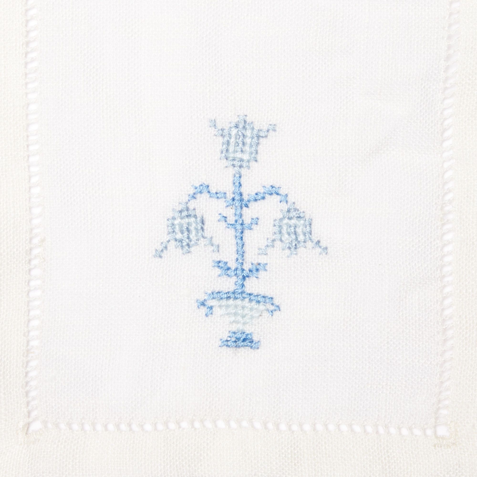 Close up of cloth napkin with blue embroidered flower