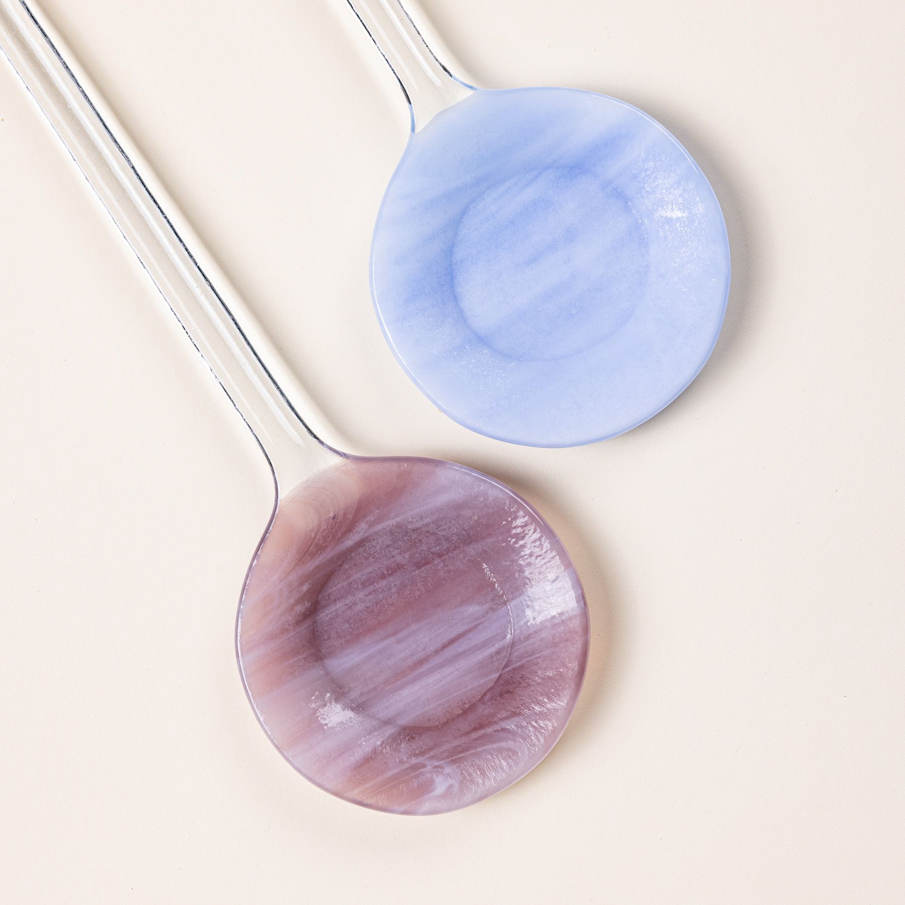 Close up of modern glass colorblocked serving spoons in periwinkle and plum colors.