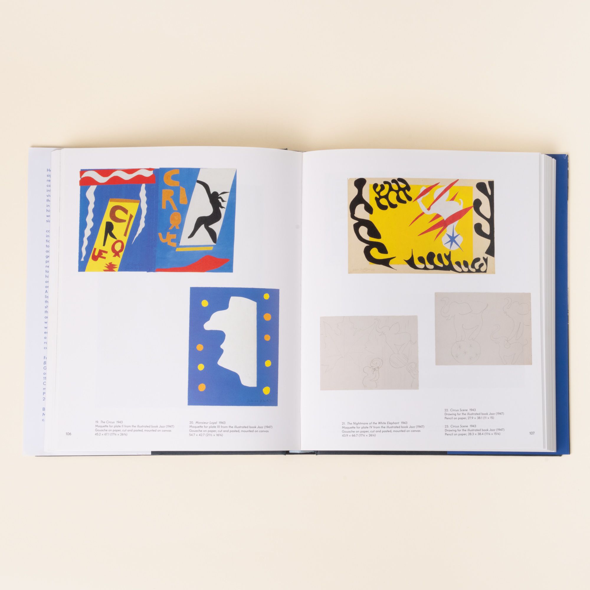 An open art book showing Henri Matisse’s colorful cut-out artworks, including bold abstract shapes in blue, yellow, red, and black.