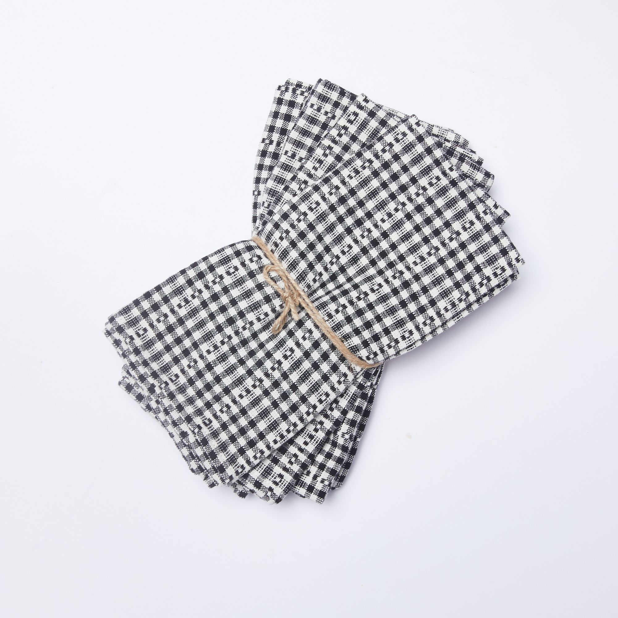 Stack of four black and white gingham cotton napkins tied with a string