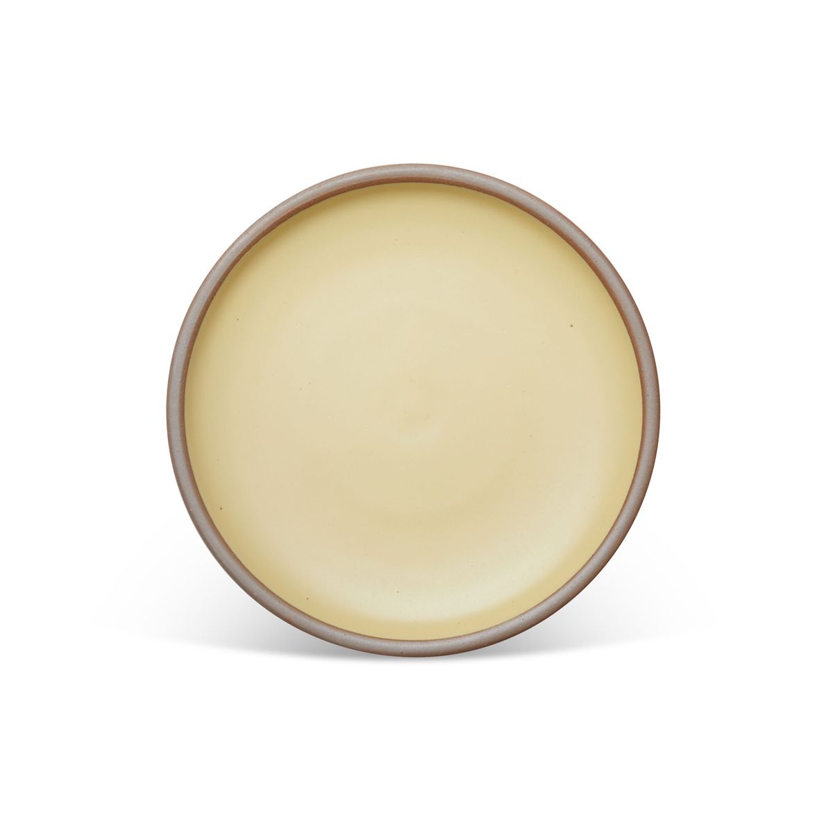 A dinner sized ceramic plate in a light butter yellow color featuring iron speckles and an unglazed rim