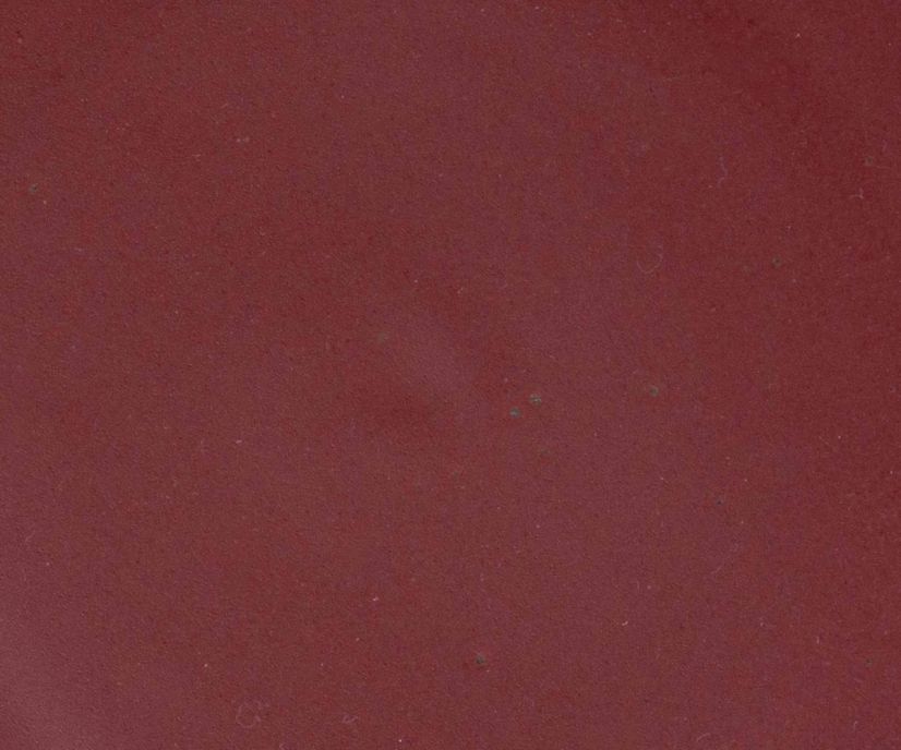 A closeup of a ceramic plate in a berry plum color featuring iron speckles