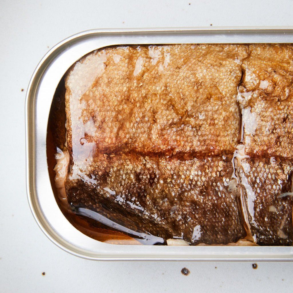 Overhead shot of pieces of smoked trout fillets in a metal rectangle