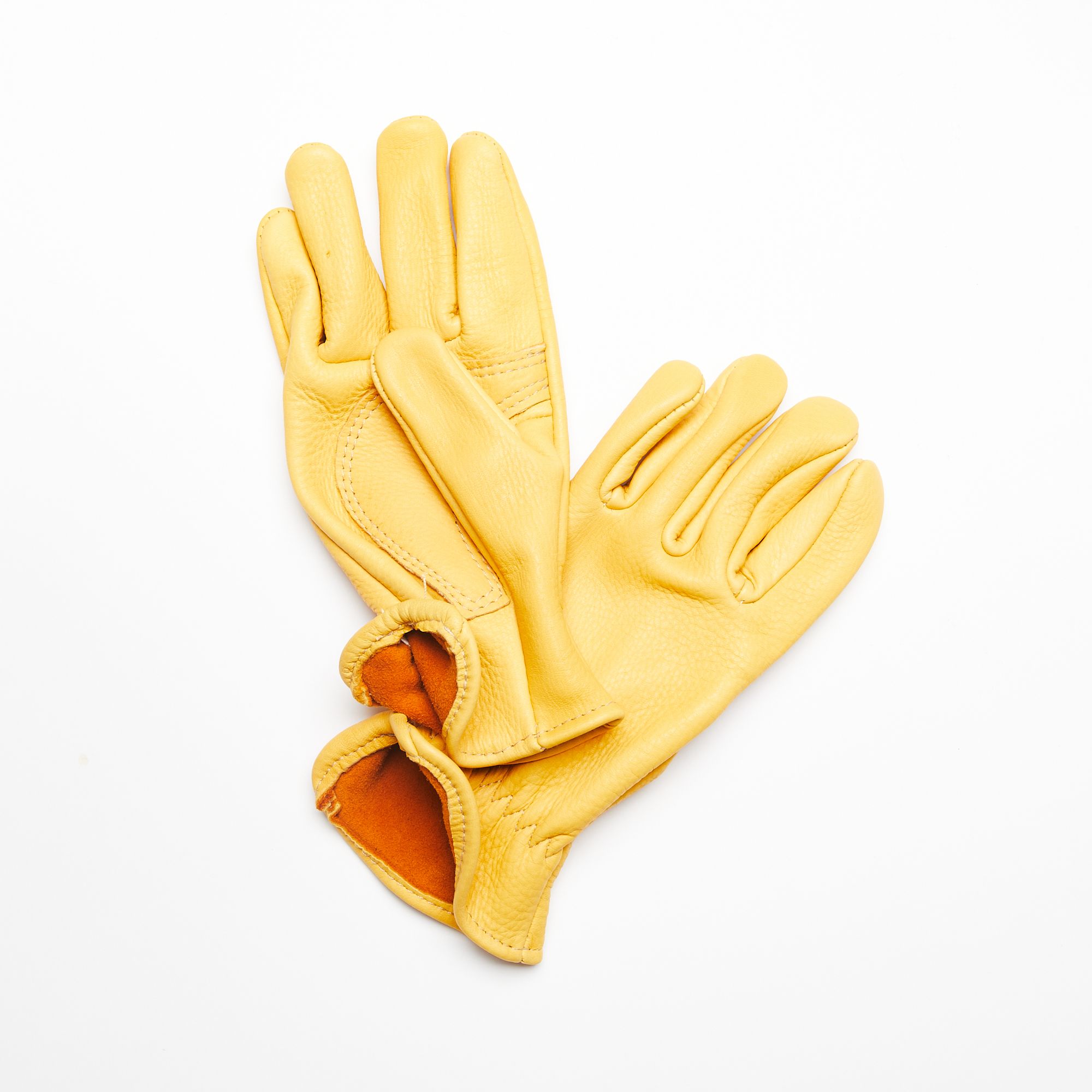 2 Buttery yellow deerskin garden gloves with brown orange interior laying flat