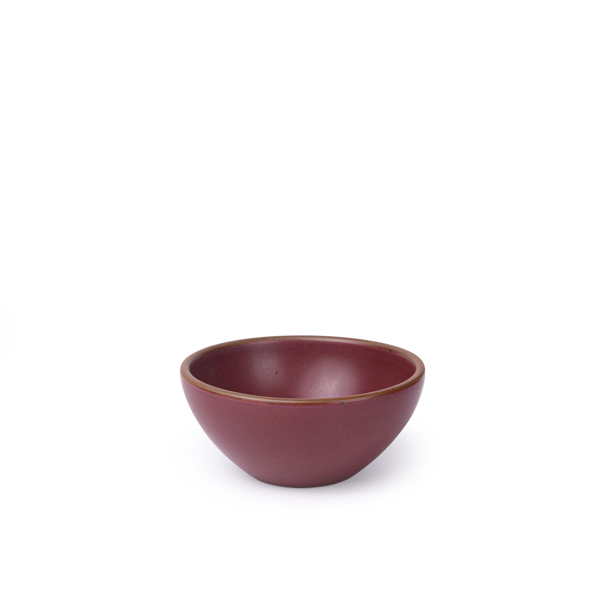 A small dessert sized rounded ceramic bowl in a plum color featuring iron speckles and an unglazed rim