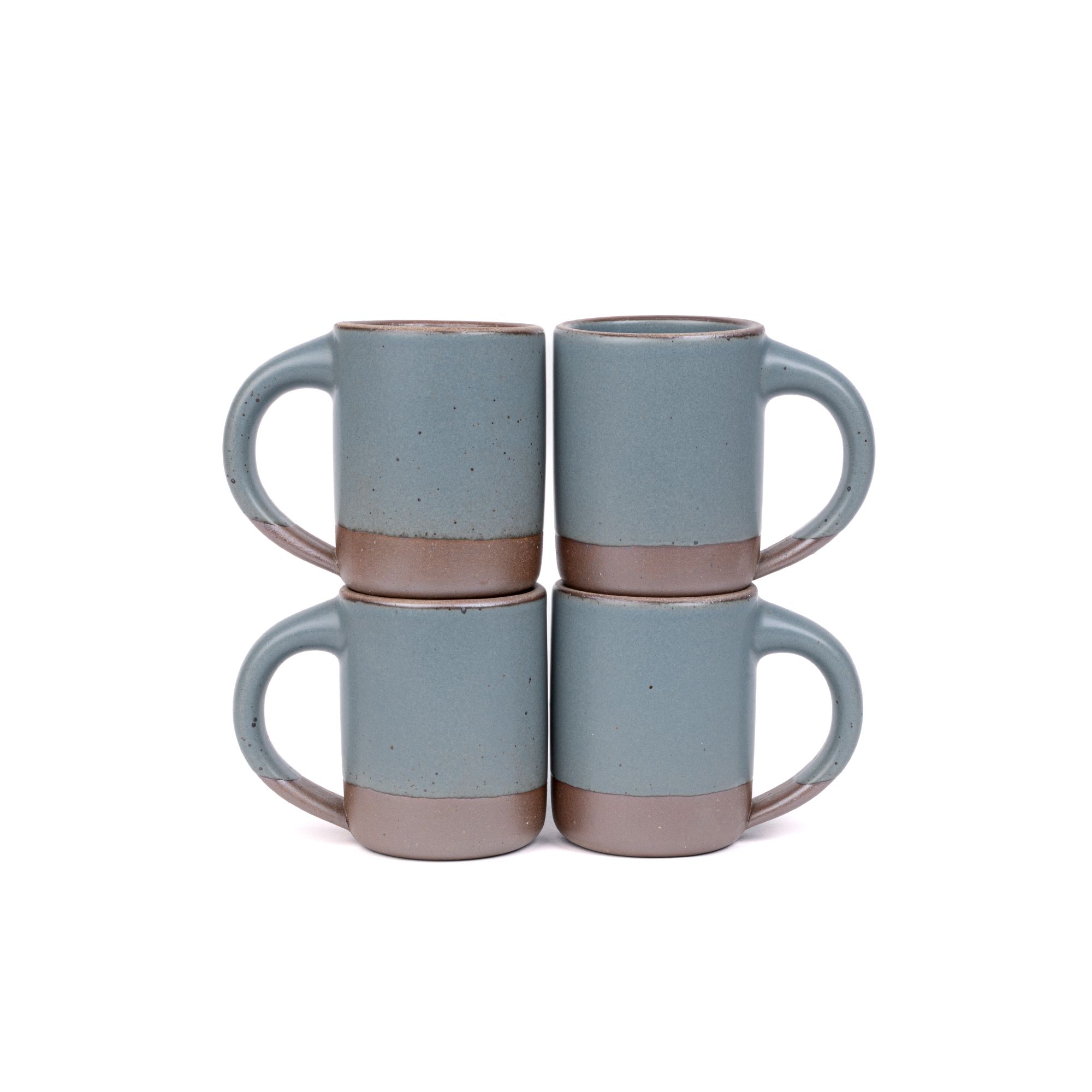 Four medium sized ceramic mugs with handles in a blue-grey color featuring iron speckles and unglazed rim