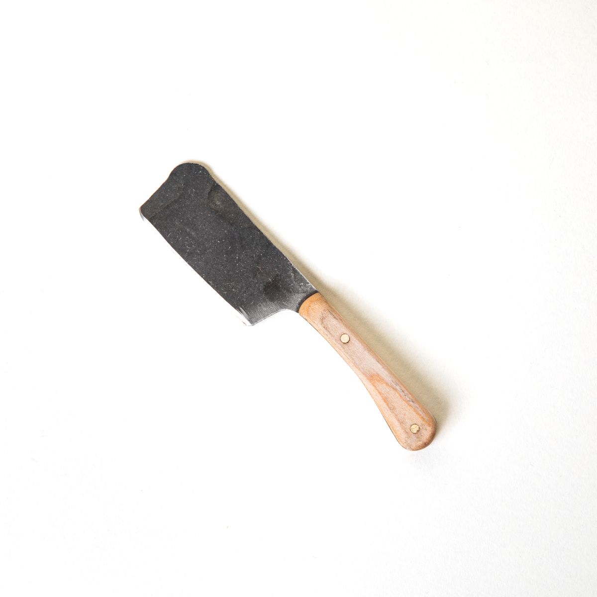 A hand-forged cheese knife with a stainless steel rectangular blade and a maple wood handle