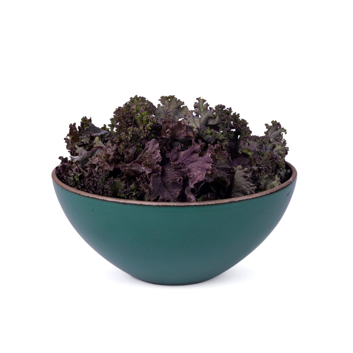 Purple lettuce in a large ceramic mixing bowl in a deep dark teal color featuring iron speckles and an unglazed rim