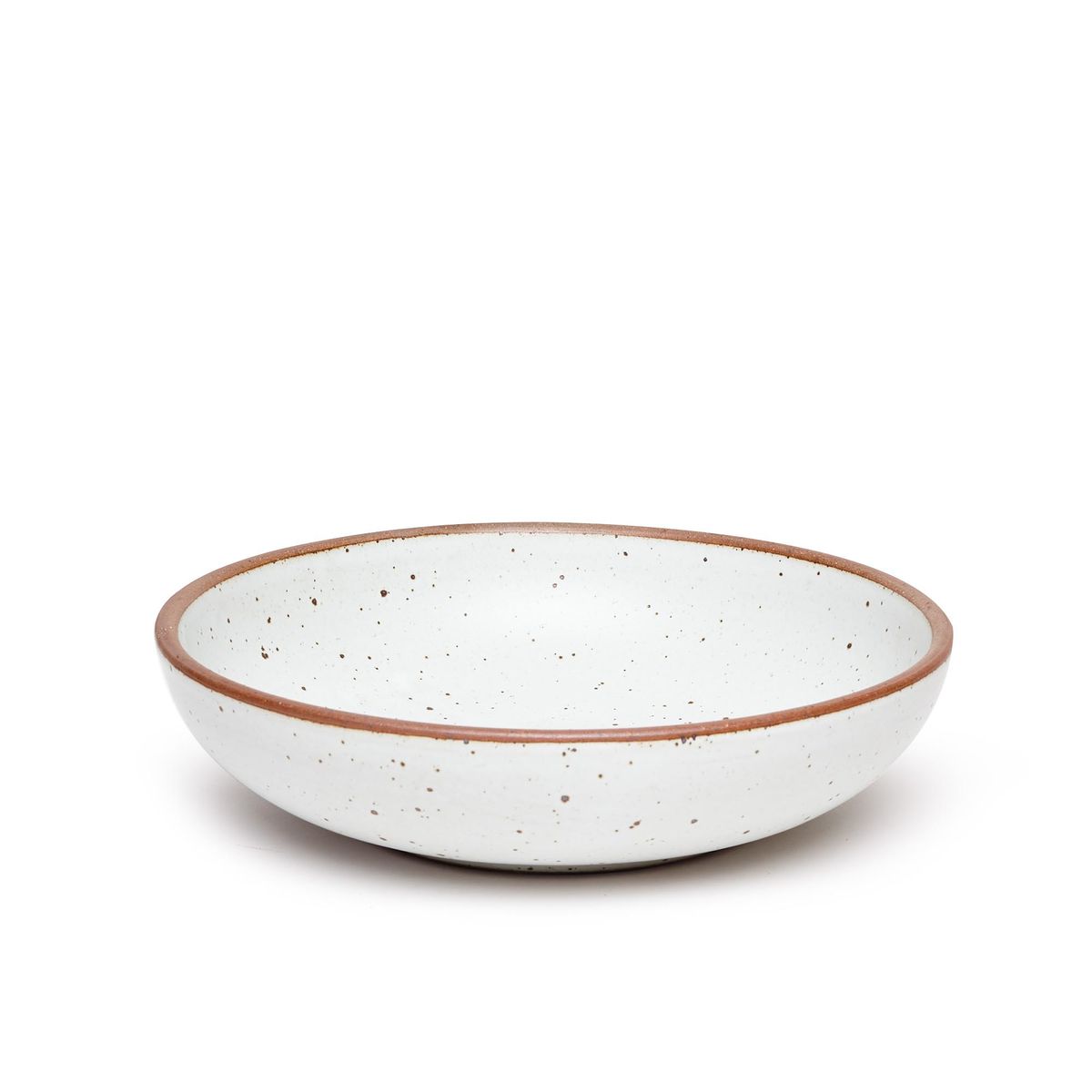 A large shallow serving ceramic bowl in a cool white color featuring iron speckles and an unglazed rim