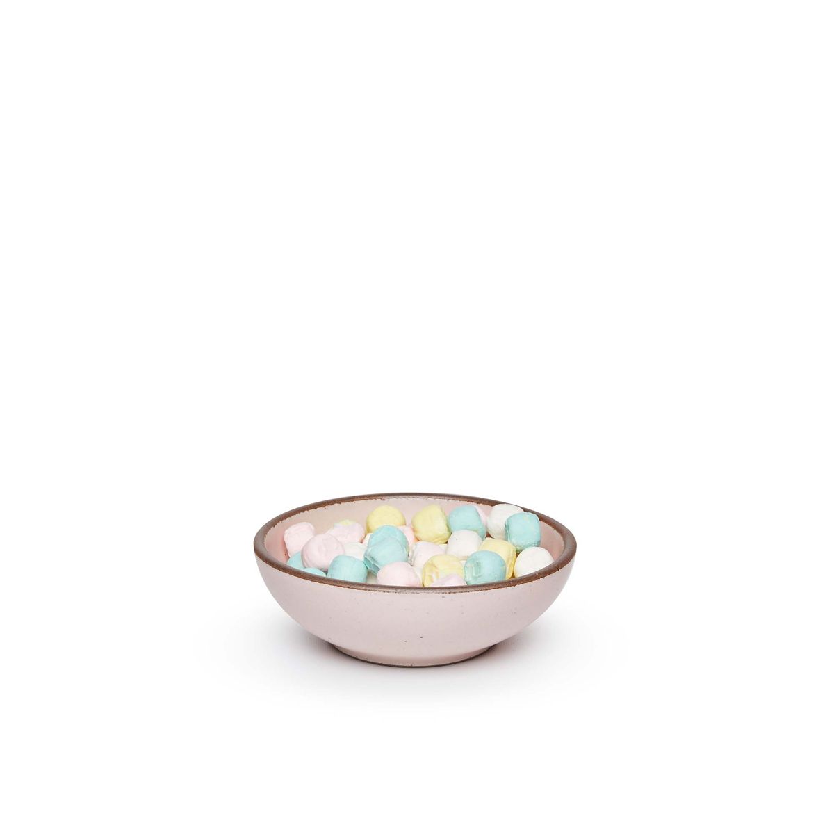 A small shallow ceramic bowl in a soft light pink color featuring iron speckles and an unglazed rim, filled with pastel marshmallows