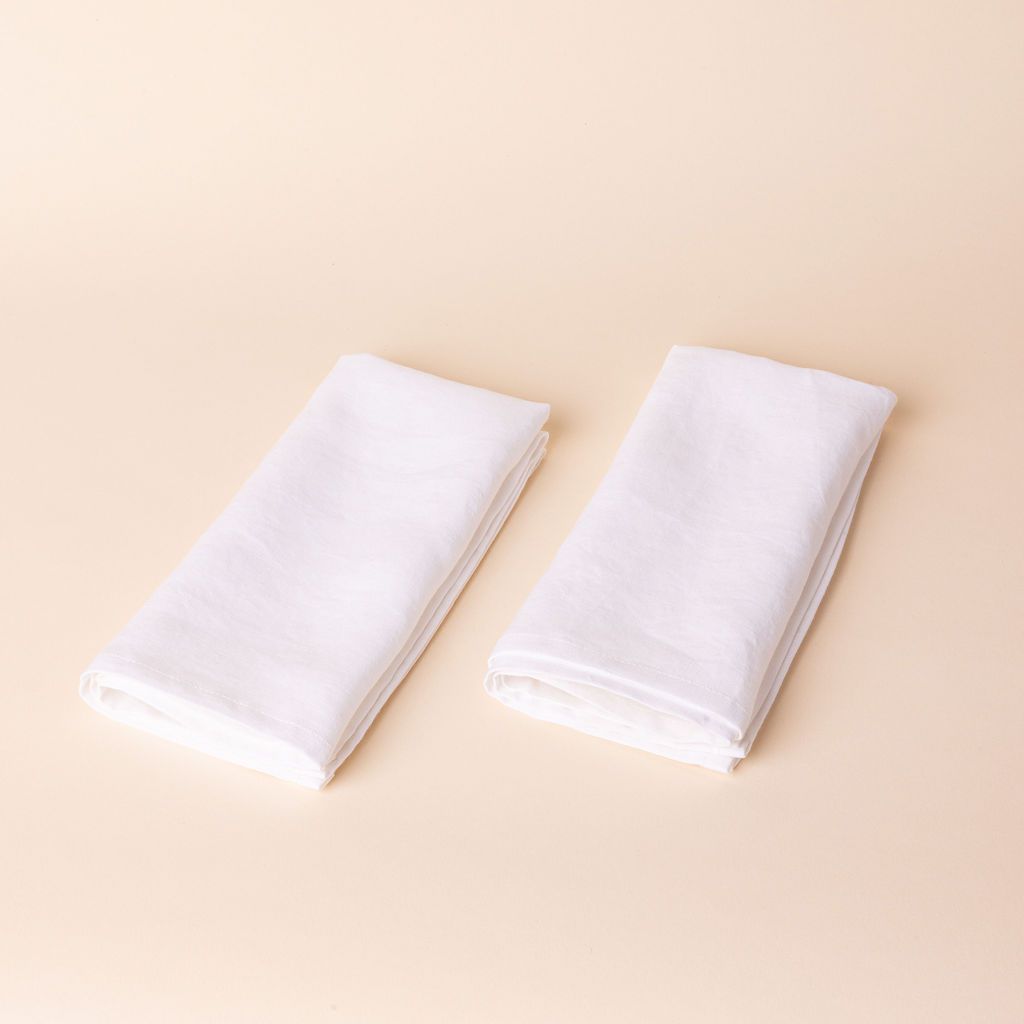 Two white napkins folded into rectangles side by side