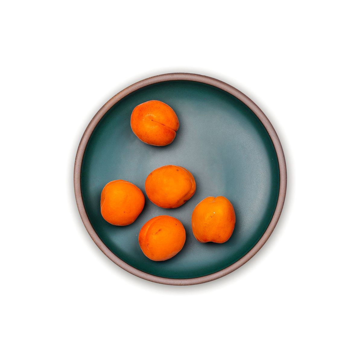 Whole clementines on a dinner sized ceramic plate in a deep dark teal color featuring iron speckles and an unglazed rim